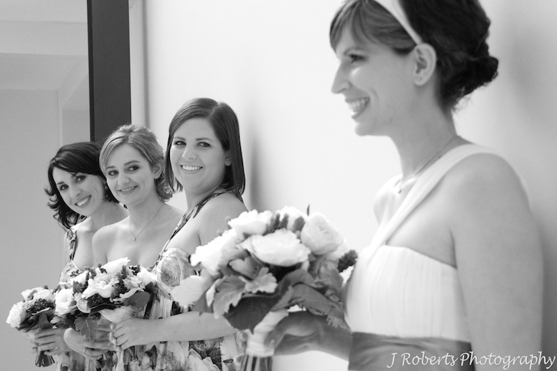 Bridesmaids looking at bride - wedding photography